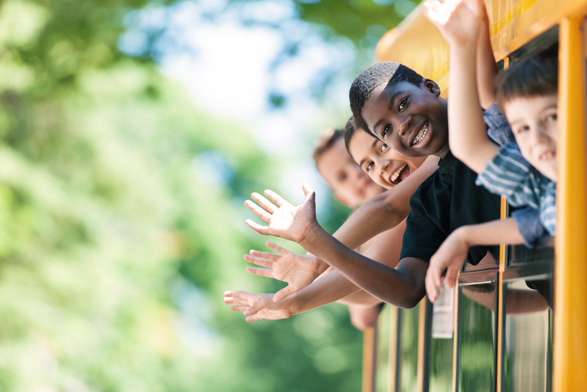 School kids hanging out bus windows